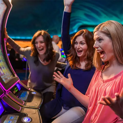 A group of players cheering at a slot machine.
